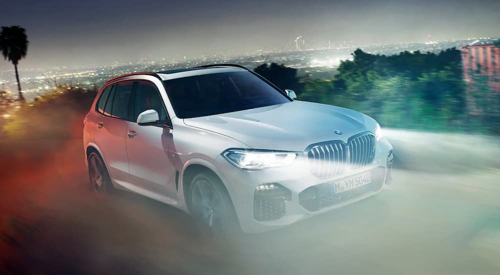 A white 2020 BMW X5 is shown from the front at an angle after leaving a dealer that has cars for sale.