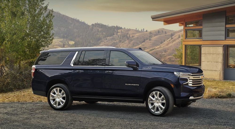 A black 2024 Chevy Suburban High Country parked in a driveway.
