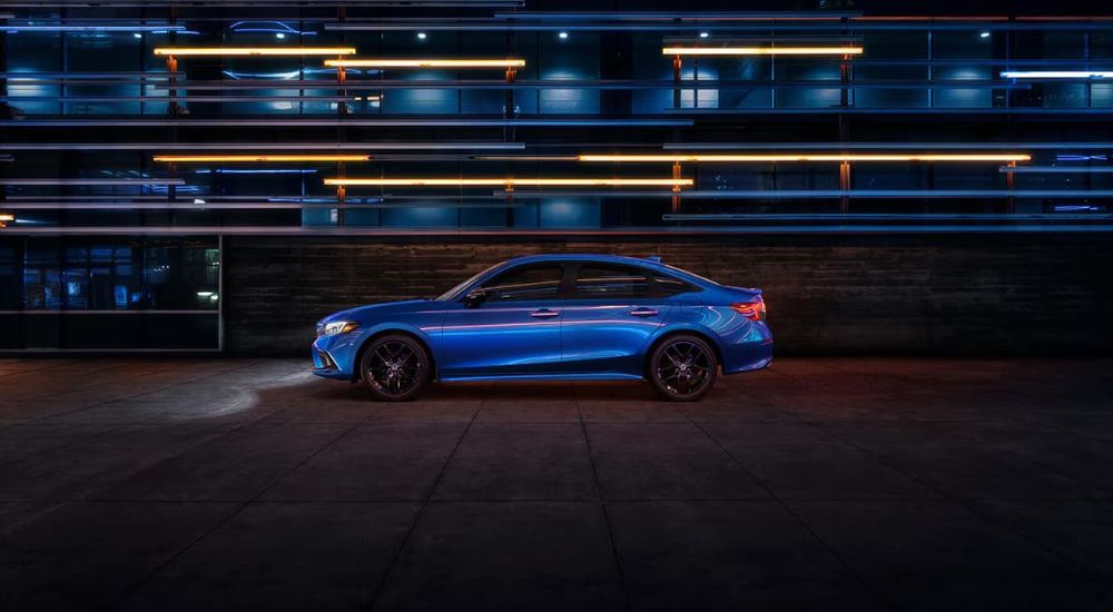 A blue 2022 Honda Civic is shown from the side at night.